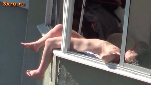 Голая телка загорает на балконе